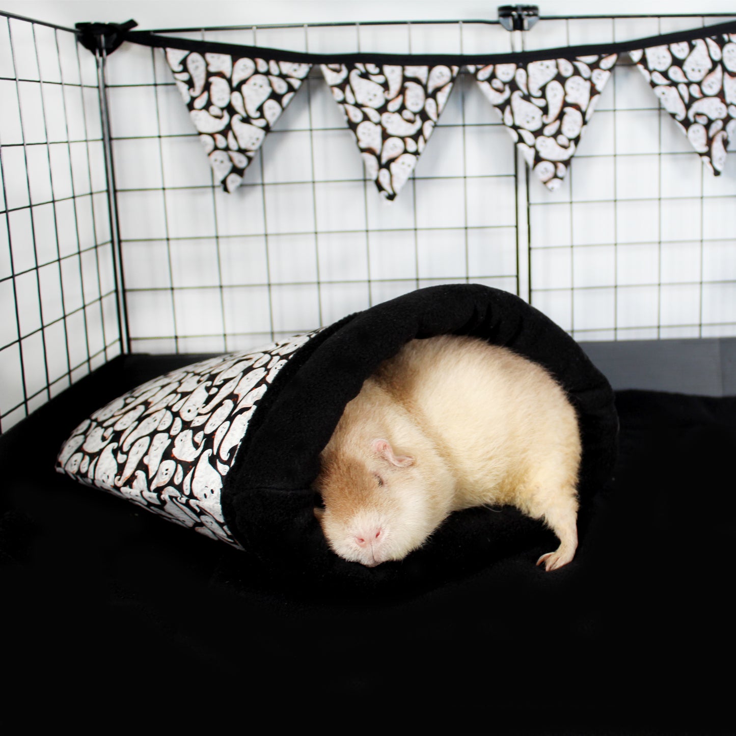 Halloween Ghost Cuddle Sack, with a Guinea pig sleeping cosy inside with it adding to the halloween theme of the cage